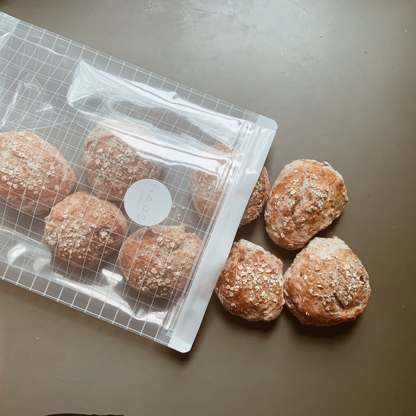 Genanvendelig snackpose med boller ved siden af.
